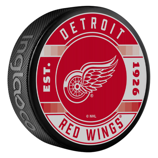 NHL Detroit Red Wings Est 1926 lenticular puck with winged wheel logo on red and white plaid backdrop